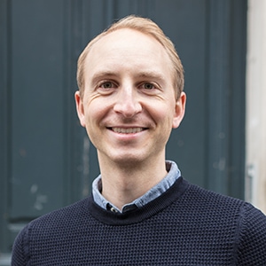 Portrait of a man in a blue shirt and sweater